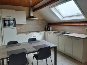 布列登Huis Pimpernel的厨房配有桌椅和窗户。