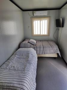 特立尼达岛Casita de Piedra Loft 7 - 8 - 9的一间小卧室,配有两张床和窗户