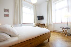 利贝雷茨健康尤马赛旅馆的一间卧室配有一张带白色床单和窗户的床。