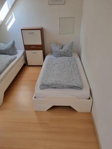 WeimarFerienwohnung/Monteurwohnung Alte Scheune bei Kassel的带两张床和梳妆台的小卧室
