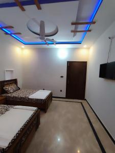 伊斯兰堡Lavish Inn Islamabad的客房设有两张床和吊扇。