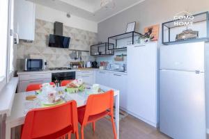 科莫Como Holiday Home Appartamento ideale per famiglie的厨房配有桌椅和白色冰箱。