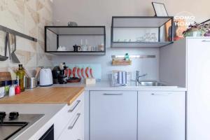 科莫Como Holiday Home Appartamento ideale per famiglie的厨房配有白色橱柜和水槽