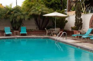 拉古纳海滩Laguna Shores Studio Suites的一个带椅子和遮阳伞的游泳池