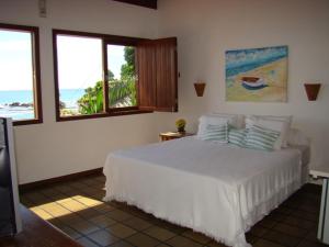 莫罗圣保罗Vista Bela Pousada的卧室设有白色床,享有海景