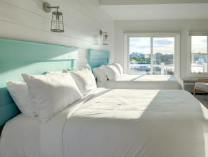 法尔茅斯Falmouth Tides的带窗户的客房内的2张白色床
