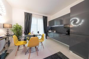 巴多利诺Magic Luxury Apartments的厨房以及带桌子和黄色椅子的用餐室。