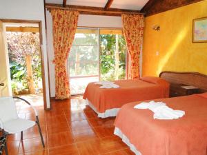 安加罗阿图帕酒店的酒店客房设有两张床和窗户。