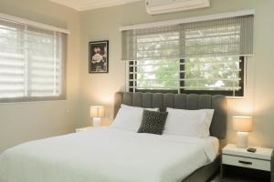 阿克拉Accra Luxury Apartments @ Silicon Square的卧室设有白色大床和窗户。