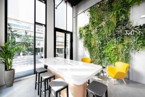 库尔布瓦Staycity Aparthotels Paris La Defense的一间设有白色桌子和黄色椅子的用餐室