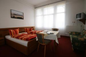 博尔库姆鲁梅尼旅馆的酒店客房配有一张床铺和一张桌子。