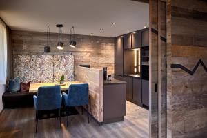 萨尔巴赫Mei.Berg premium view Appartements的厨房以及带桌子和蓝色椅子的用餐室。