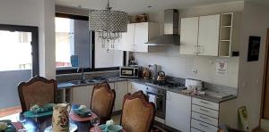 普拉亚YOUR HOME AWAY FROM HOME的厨房配有白色橱柜和桌椅