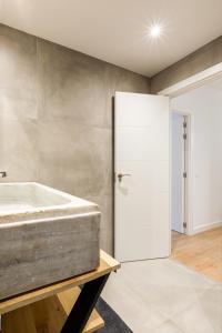 希洪Lujo, comodidad y espacio Gijon centro的带浴缸和玻璃门的浴室
