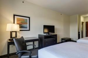 塞克斯顿塞克斯顿智选假日套房酒店的酒店客房设有两张床、一张桌子和一台电视。
