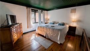 科洛尼亚-德尔萨克拉门托Posada de la Flor的一间卧室配有一张床和一台电视