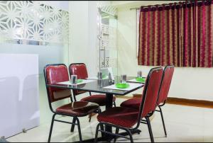 维杰亚瓦达Hotel Menaka的一间带桌子和四把椅子的用餐室