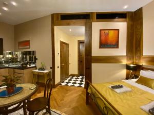 第比利斯Luxury Studio @ Axis Towers in Heart of Tbilisi的一间卧室配有一张床铺和一张桌子,还设有一间厨房