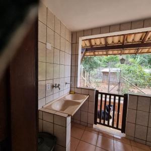 尤西德福拉Granja das Rosas的浴室设有水槽,狗儿从窗户望出去