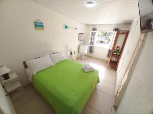 布希奥斯Casa Colomba的一间小卧室,配有绿色的床和窗户