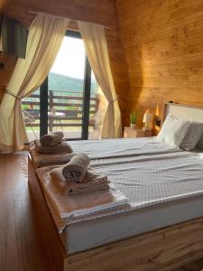 维尔蒂尼克Vila Grujic的一间卧室配有带毛巾的床和窗户。