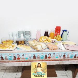 阿帕雷西达Pousada Jesus Misericordioso的一张桌子上放着食物和雕像