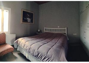 KrokeaíArtemis House的一间卧室配有一张大床和一把椅子
