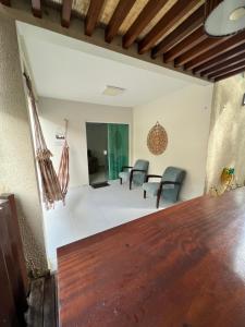 巴雷里尼亚斯Casa em Condomínio agradável com fundo pro rio的客厅配有木桌和椅子