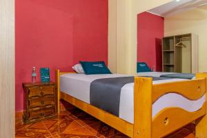 伊察Ayenda Muñoz的一间卧室设有一张床和红色的墙壁