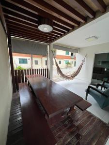 巴雷里尼亚斯Casa em Condomínio agradável com fundo pro rio的客厅配有木桌和吊床