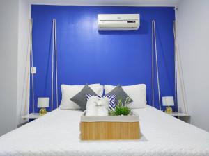 约帕尔Apartaestudio Totalmente Amoblado - Centro的蓝色的卧室设有白色的床和蓝色的墙壁