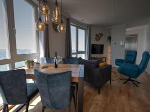 ScherpenissePremium apartment in Scherpenisse with roofed terrace的客厅配有桌子和蓝色椅子