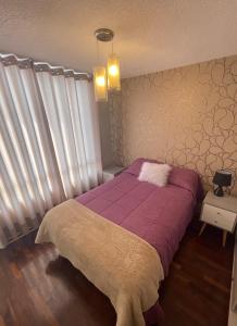 利马Departamento completo en Miraflores Surquillo的一间卧室配有一张带紫色毯子的床