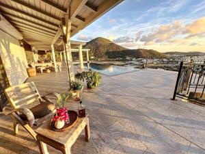 格兰德凯斯Frangipani Room in shared Villa Diamant, swimming pool, sea view的屋顶上带椅子和桌子的庭院