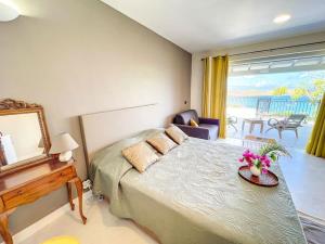 格兰德凯斯Frangipani Room in shared Villa Diamant, swimming pool, sea view的一间卧室配有一张床和一张鲜花桌子