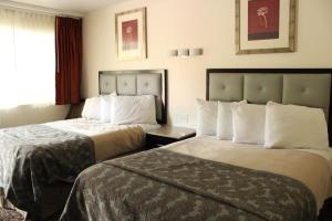 普尔曼American Travel Inn的酒店客房设有两张床和窗户。