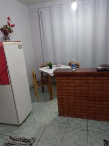 坎波斯杜若尔当Kitnet Recanto de Campos-Pertinho do Centro的厨房配有桌子和白色冰箱。
