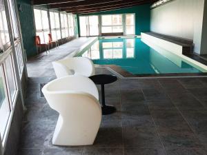 若西耶Studio Jausiers, 1 pièce, 4 personnes - FR-1-165B-45的游泳池旁的游泳池配有两把白色椅子