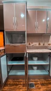 布赖代Reef Al Qassim Hotel Apartments的厨房配有棕色橱柜和台面