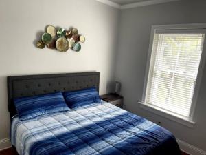 圣奥古斯丁Cozy & Quiet Two Bedroom Condo In The Heart Of Historic St. Augustine的一间卧室配有一张蓝色棉被和两个窗户。