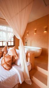 乌鲁瓦图Terra Cottages Bali的一间卧室配有浴缸和一张带枕头的床。