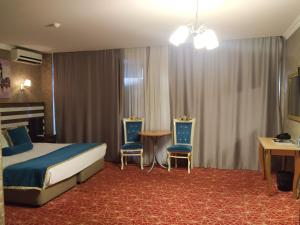 巴库巴库画廊酒店的酒店客房配有一张床、两把椅子和一张桌子