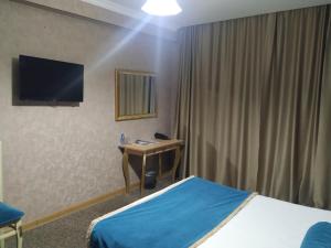 巴库巴库画廊酒店的酒店客房配有一张床、一张书桌和一台电视。