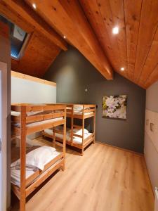 CustinneGite Li School的带木天花板的客房设有两张双层床。