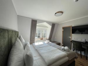 Brilon-WaldSchlosshotel Brilon-Wald的一间卧室配有一张带白色床单的床和一扇窗户。