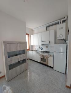卡斯蒂利翁切洛Appartamento Castiglioncello 600 mt dal mare的厨房配有白色橱柜、炉灶和冰箱。