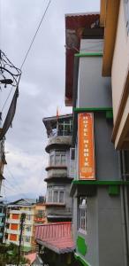 甘托克Hotel Nindik的一边有橙色标志的建筑