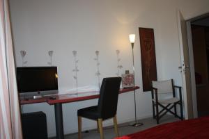 多瑙河畔诺伊堡埃姆夫鲁斯酒店的客房设有一张桌子、一台电视和两把椅子