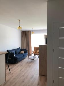 厄尔科Ełk Vacation Apartament的客厅配有蓝色的沙发和椅子