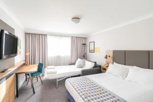 赫默尔亨普斯特德Holiday Inn Hemel Hempstead M1, Jct. 8, an IHG Hotel的一间酒店客房,配有一张床和一台电视